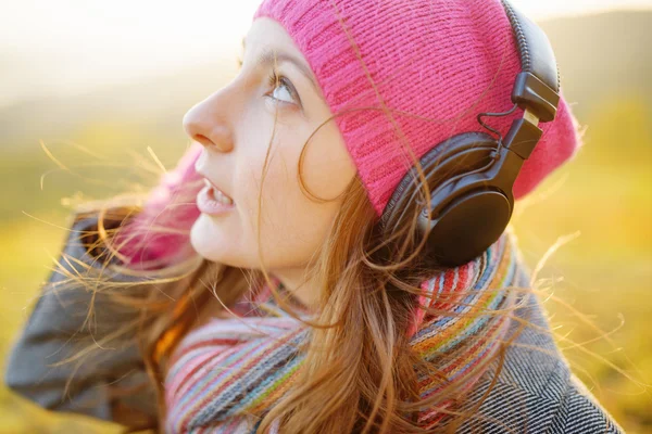 Young woman enjoying a music in the fall season. Autumn outdoor Stock Photo