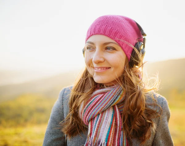 Young woman enjoying a music in the fall season. Autumn outdoor — Stock Photo, Image