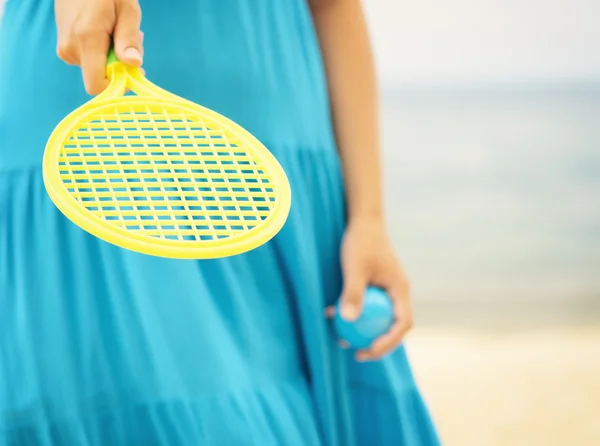 Donna in abito blu giocare a tennis sulla spiaggia — Foto Stock