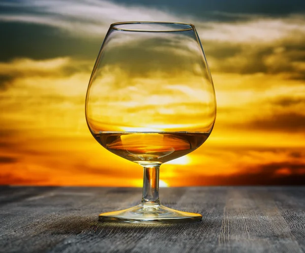 Glas Brandy am Abendhimmel Hintergrund — Stockfoto