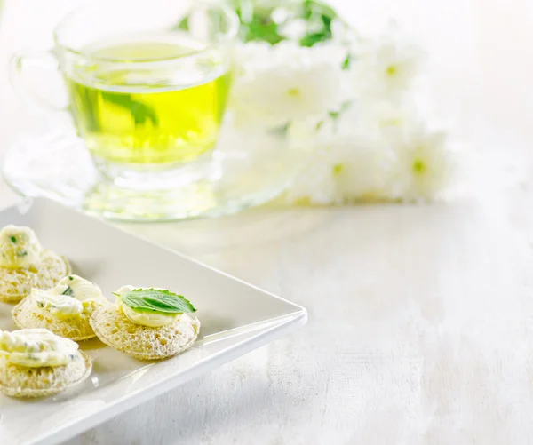 Mehrere Kanapees und eine Tasse Kräutertee. — Stockfoto