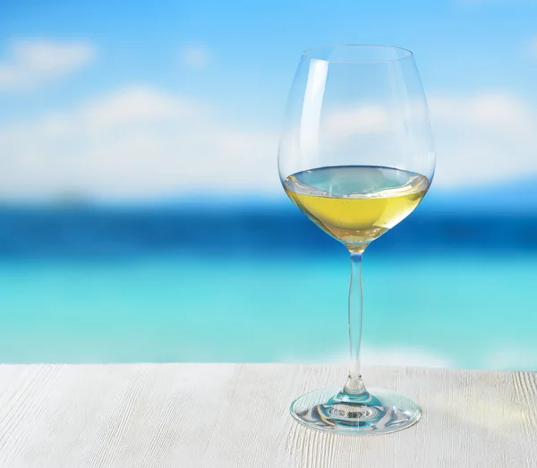 Sklenka vína na pláži pozadí — Stock fotografie
