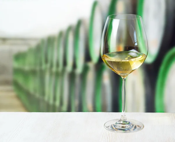 Verre de vin et tonneaux en bois dans la cave — Photo