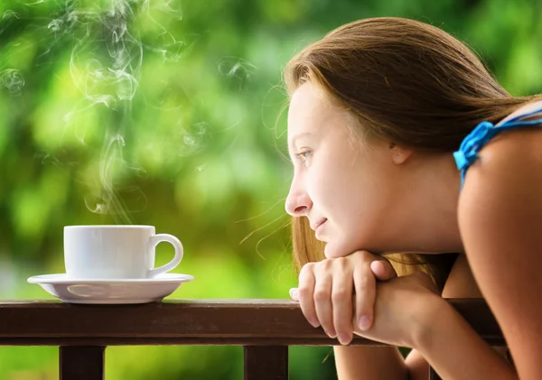 Una joven bebiendo cofee en un jardín. Retrato al aire libre — Foto de Stock