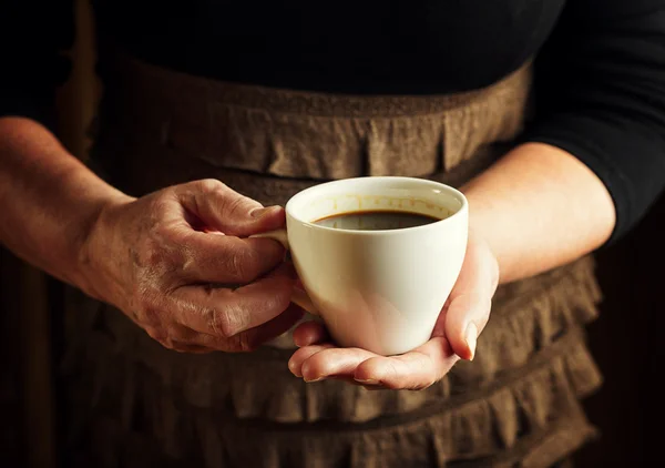 Hände einer Seniorin mit einer Tasse Kaffee — Stockfoto