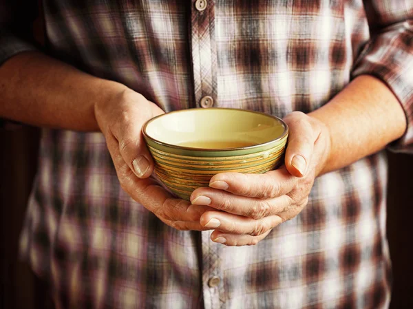 Hands of senior woman holding cup of tea — Stock Photo, Image