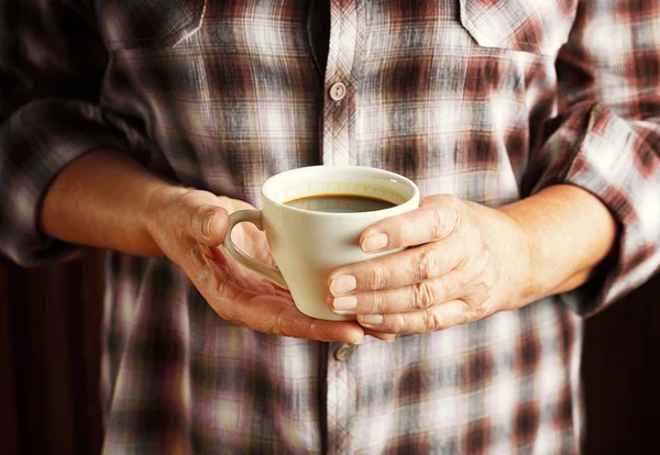 Hands of senior woman holding cup of coffee — Stock Photo, Image