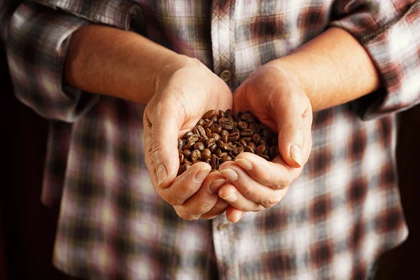 Senior woman holding coffee beans — Stock Photo, Image
