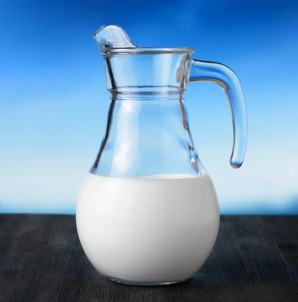 Džbán mléka na pozadí oblohy. půl plný džbán — Stock fotografie