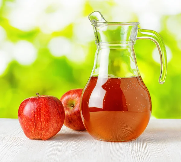 Jug of apple juice on nature background — Stock Photo, Image