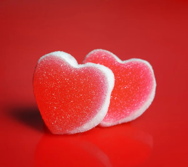 Cukor szívek piros háttér — Stock Fotó