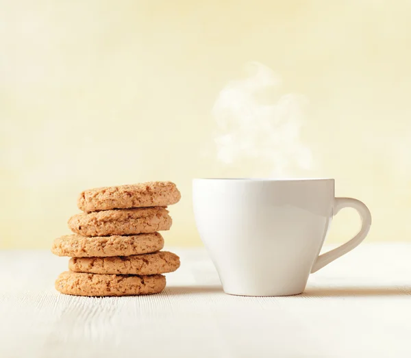 Havermout cookies en kopje koffie op houten tafel — Stockfoto