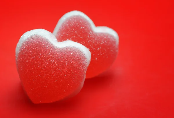 Cukor szívek piros háttér — Stock Fotó