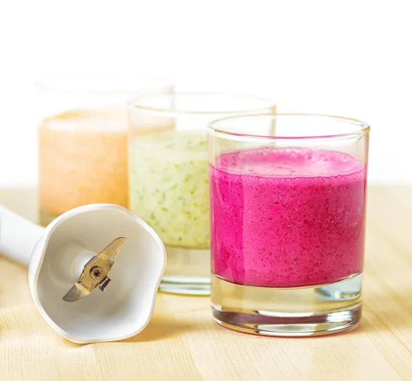 Batido de frutas sobre mesa de madera sobre fondo blanco — Foto de Stock