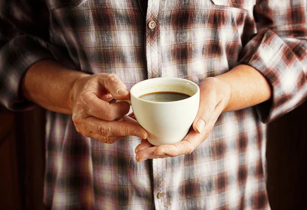 Händerna på äldre kvinna med kopp kaffe — Stockfoto