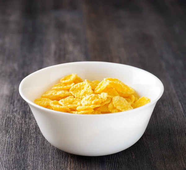 Bowl of cornflakes on wooden table — Stock Photo, Image