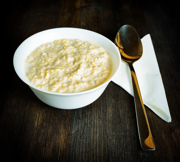 Bowl of oat porridge on wooden table — Stock Photo, Image