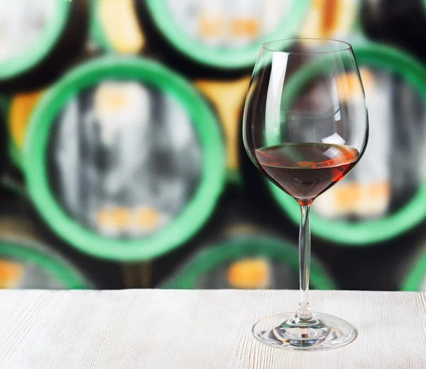 Verre de vin et tonneaux en bois dans la cave — Photo