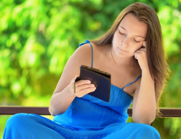 Jeune femme lisant un livre électronique. Portrait extérieur — Photo