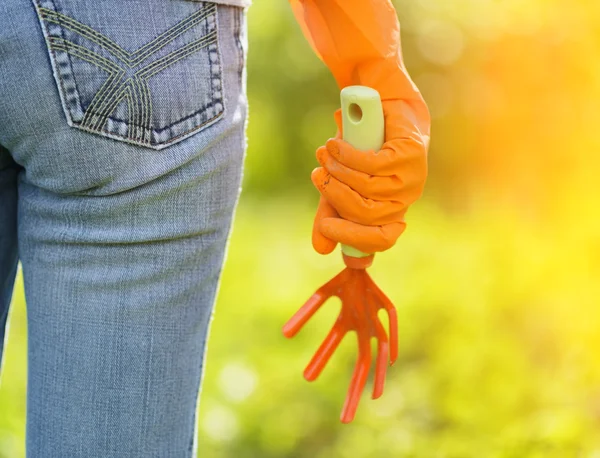 Kvinna i orange handskar arbetar i trädgården — Stockfoto