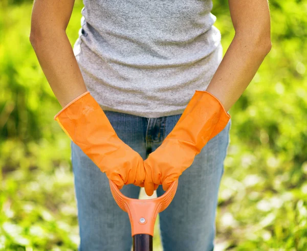 Frau in orangefarbenen Handschuhen arbeitet im Garten — Stockfoto