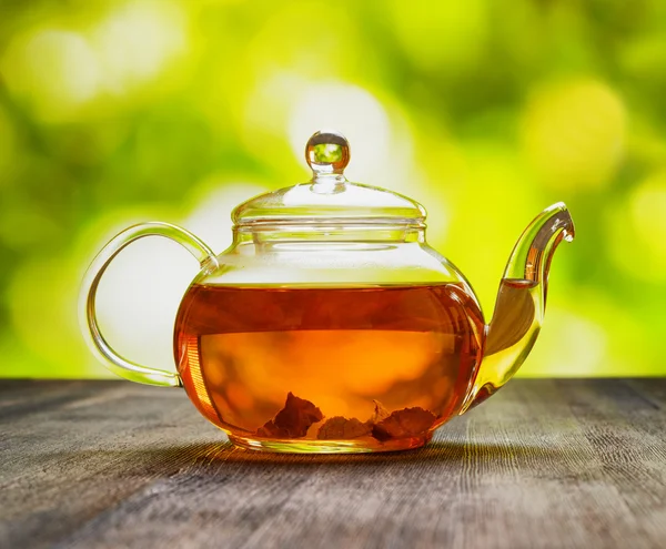 Teapot of fresh tea on natural background — Stock Photo, Image