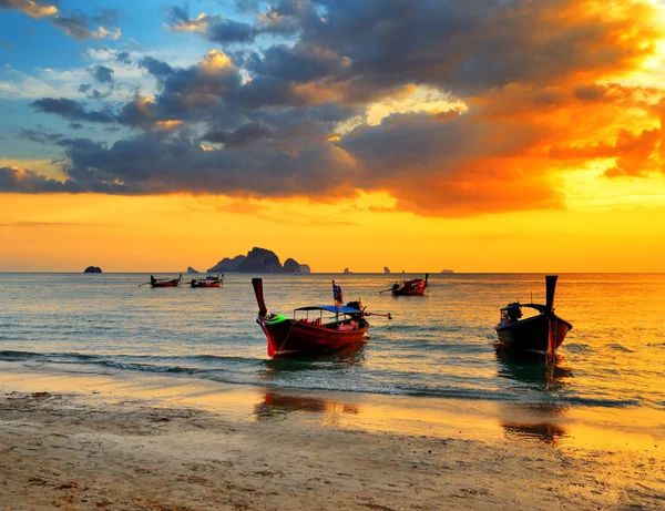 Traditional thai boats at sunset beach Stock Photo