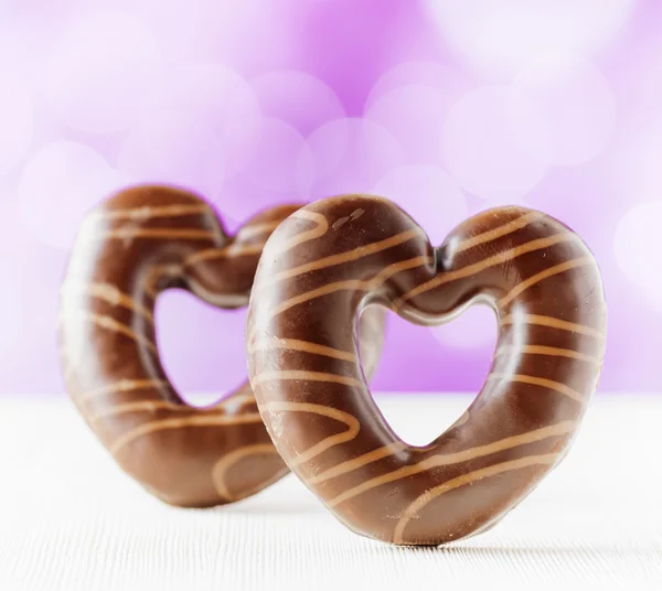 Chocolate hearts on purple backgroud — Stock Photo, Image