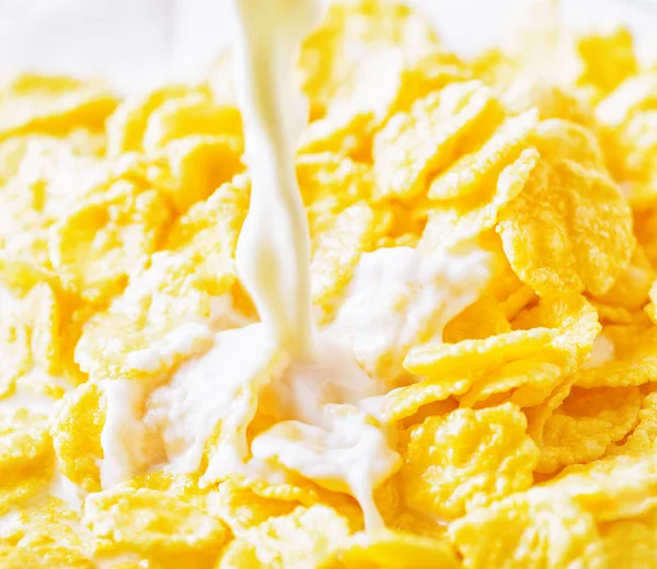 Milk pouring into corn flakes — Stock Photo, Image