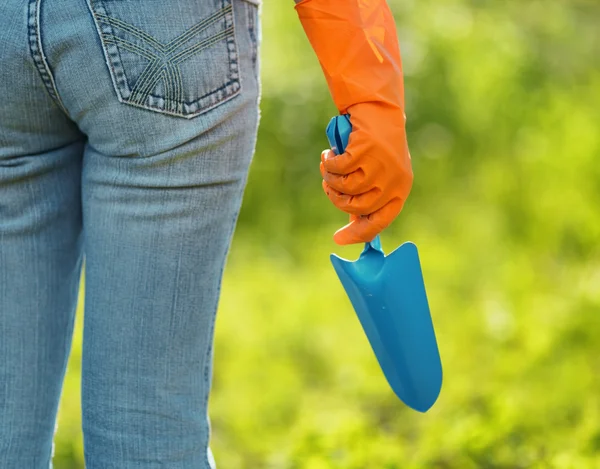 Kvinna i orange handskar arbetar i trädgården — Stockfoto