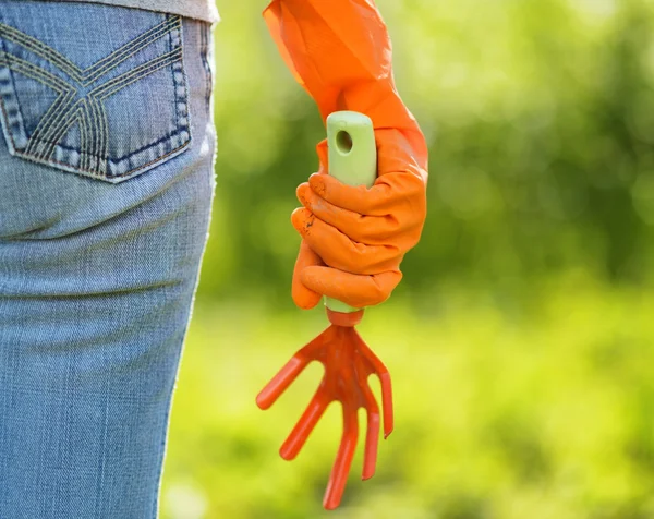 Vrouw in oranje handschoenen werken in de tuin — Stockfoto