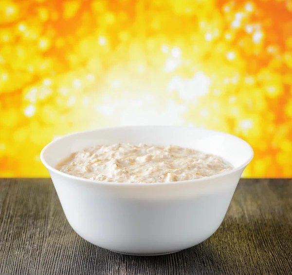 Bowl of oat porridge on nature background — Stock Photo, Image