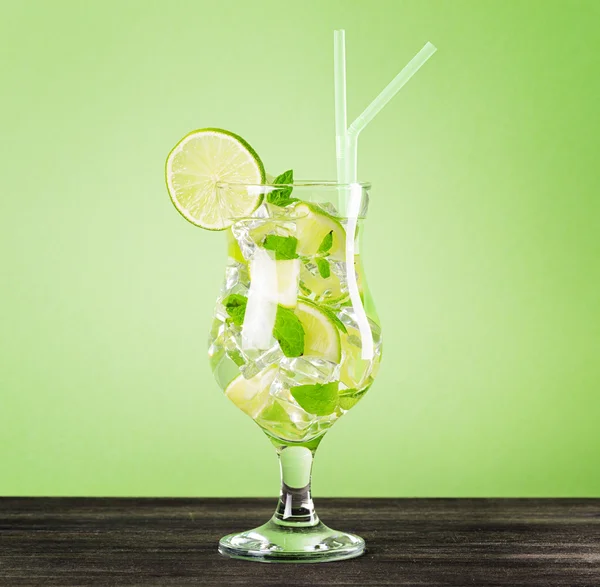 Glass of mojito cocktail on pastel green background — Stock Photo, Image