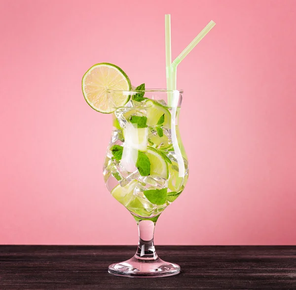 Glass of mojito cocktail on pastel pink background — Stock Photo, Image