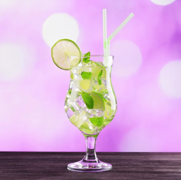 Glass of mojito cocktail on pink background — Stock Photo, Image