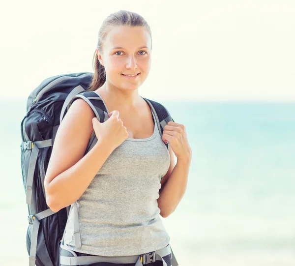 Unga kvinnliga backpacker på en strand — Stockfoto