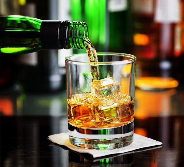 Whiskey pouring a glass in a bar