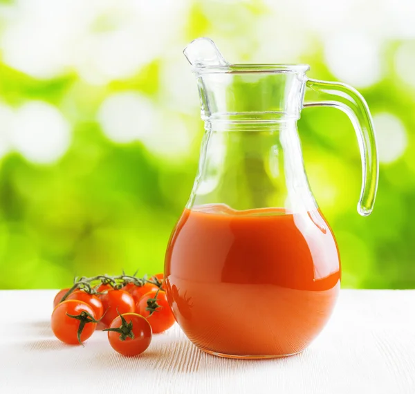 Jarra de jugo de tomate sobre fondo natural. Mitad jarra llena — Foto de Stock