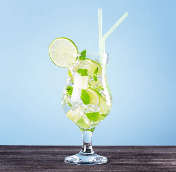 Glass of mojito cocktail on pastel blue background — Stock Photo, Image