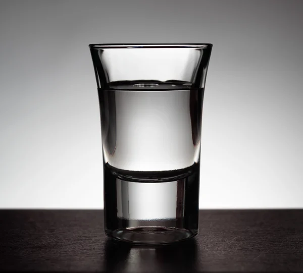 Vaso de vodka sobre fondo gris — Foto de Stock