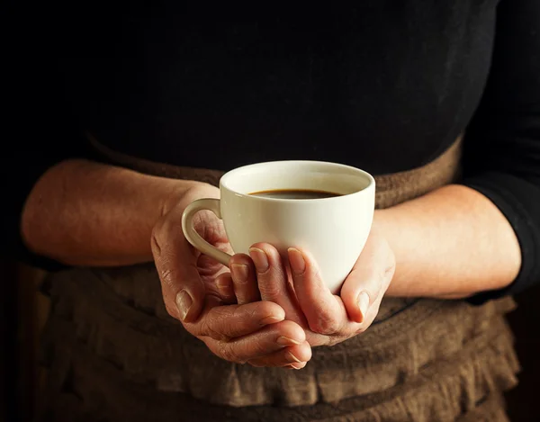 Händerna på äldre kvinna med kopp kaffe — Stockfoto