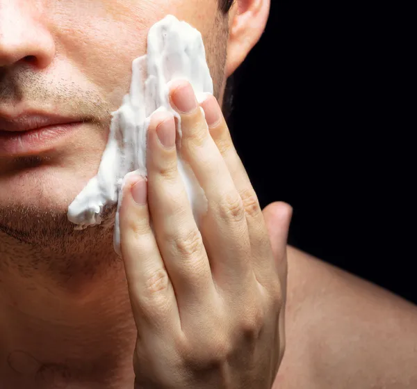 Mladý muž použitím pěny na holení — Stock fotografie