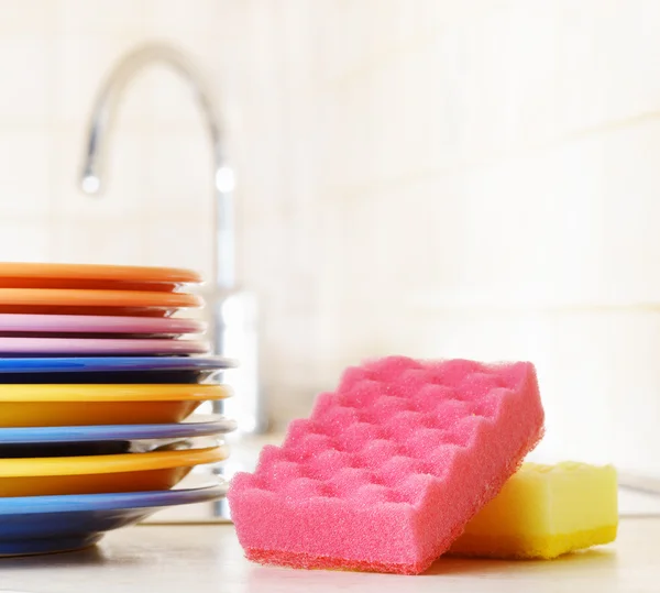 Vários pratos e uma esponja de cozinha. Conceito de lavagem de pratos — Fotografia de Stock