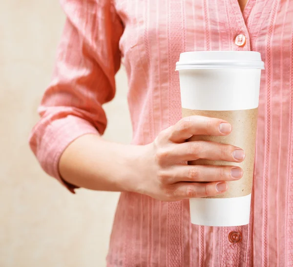 Junge Frau hält einen Becher Kaffee in der Hand — Stockfoto