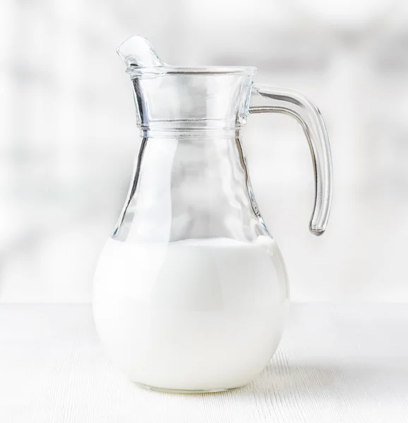 Caraffa di latte sullo sfondo della fabbrica. Brocca mezza piena — Foto Stock