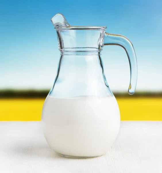 Caraffa di latte su fondo prato. Brocca mezza piena — Foto Stock
