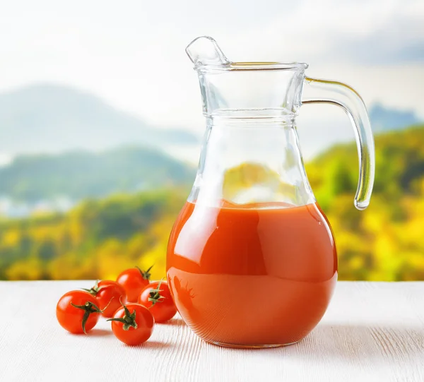 Jarra de jugo de tomate sobre fondo natural. Mitad jarra llena — Foto de Stock