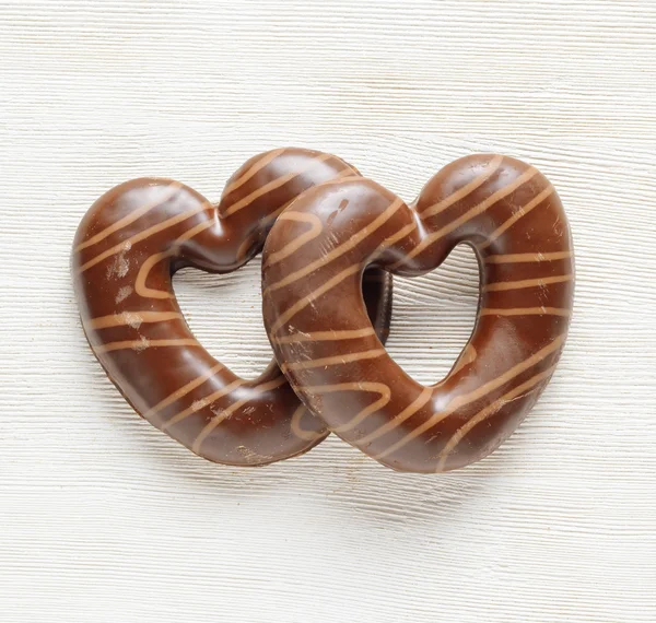Chocolate hearts on white wooden table. — Stock Photo, Image