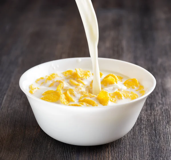 Bowl of cornflakes on wooden table — Stock Photo, Image