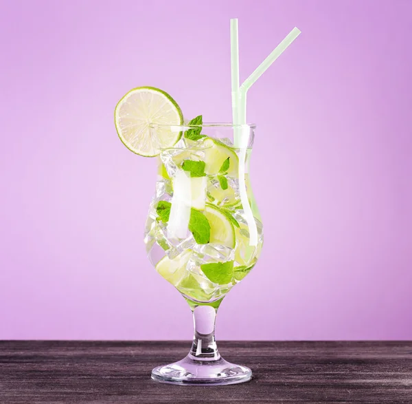 Glass of mojito cocktail on pastel pink background — Stock Photo, Image